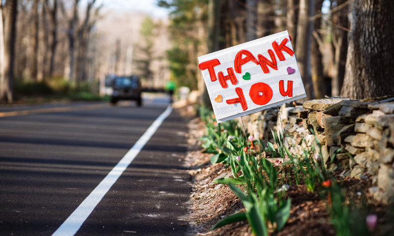 road with flowers and thank you sign